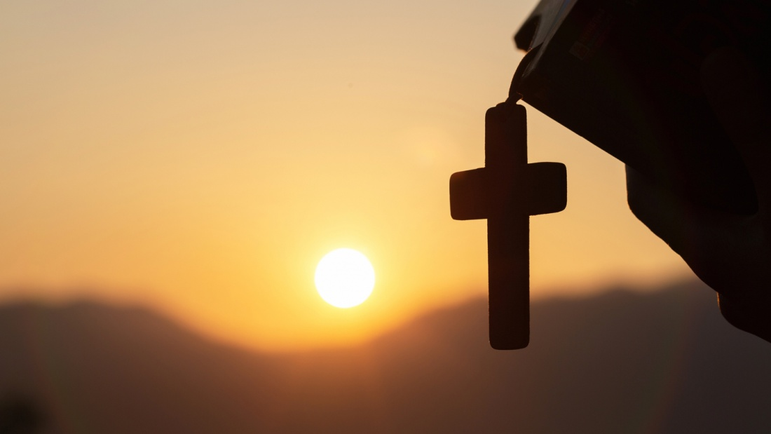 Kreuz im warmen Licht der untergehenden Sonne